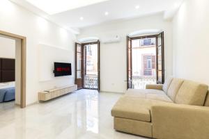 ein Wohnzimmer mit einem Sofa und einem TV in der Unterkunft La Suite Cagliari - Cagliari centro in Cagliari