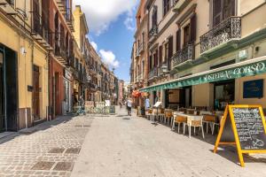 eine Straße in einer Stadt mit Tischen und Stühlen in der Unterkunft La Suite Cagliari - Cagliari centro in Cagliari
