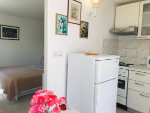 cocina con nevera blanca y mesa con flores en Apartments Ana Hvar, en Hvar