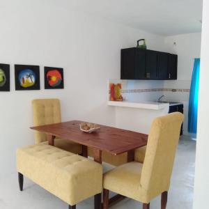 a dining room table with two chairs and a kitchen at Aparta Hotel Ana Luis in Río San Juan