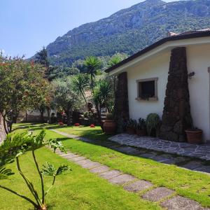 ein Haus mit einem Garten und einem Berg im Hintergrund in der Unterkunft Casa Bados in Dorgali