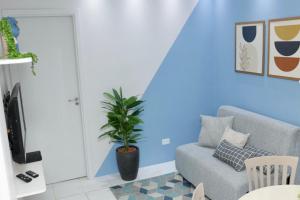 een blauwe woonkamer met een bank en een plant bij Flat na Fazenda Monte Castelo Gravatá Sairé - Mod 12 - Flat 9 in Gravatá