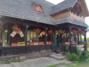 Una casa con una tienda con flores. en Complex Traditional Căsuța Bunicilor-Breb en Breb