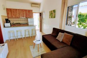 a living room with a couch and a kitchen at Precioso Bungalow 12 by CASAS COCODRILO in Playa del Ingles