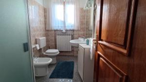 a bathroom with a toilet and a sink and a toilet istg at Casa da Emanuela in Drežnik Grad