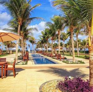 un complejo con una piscina con palmeras en Villa Mandara, en Fortaleza