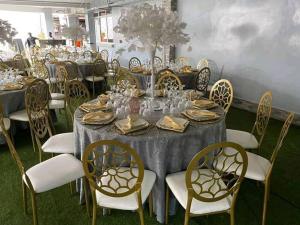 a long table with chairs and plates and wine glasses at Hôtel Freesia in Yaoundé
