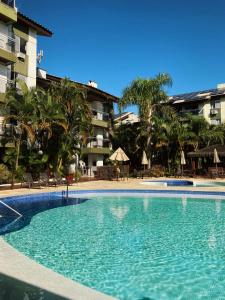 a large swimming pool in front of a building at Belluno Apart Hotel in Florianópolis