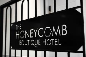 um sinal para o hotel boutique favo de mel numa cerca em The Honeycomb Boutique Hotel em Golem