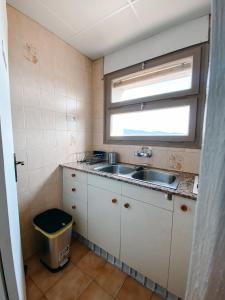 uma pequena cozinha com um lavatório e uma janela em Apartamento en Torre Valentina con vista al mar em Calonge
