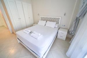 1 dormitorio con 1 cama blanca y 2 toallas en Apartment for rent with 2 bedrooms, en Tánger