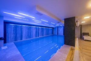 a large swimming pool in a room with blue lighting at Graziella Gold Hotel in Istanbul +24 photos