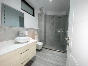 uma casa de banho com um lavatório, um chuveiro e um WC. em The Honeycomb Boutique Hotel em Golem