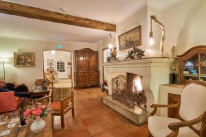 a living room with a fireplace and a couch at La Ferme D'Augustin in Saint-Tropez