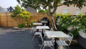 - un ensemble de tables et de chaises sur une terrasse dans l'établissement Suite Deluxe, voyages d'affaires., à Saint-Nazaire