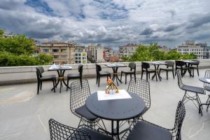 eine Terrasse mit Tischen und Stühlen auf dem Dach in der Unterkunft Graziella Gold Hotel in Istanbul