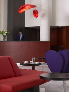 una camera con divano rosso e tavolo con sedie di Kyma Suites Beach Hotel a Rethymno