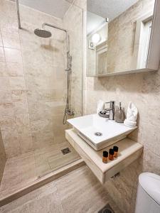 La salle de bains est pourvue d'un lavabo et d'une douche. dans l'établissement Harmonia Bungalows & Pool, à Sveti Stefan