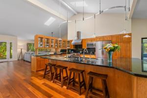 eine Küche mit einer großen Insel mit Barhockern in der Unterkunft 4Br 2Ba Newly Furnished Princeville Home, AC, Pool, Tennis in Princeville