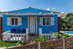 een blauw huis met een wit hek ervoor bij G&G Villas in Spartia