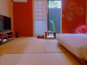 京都桃夭庵 touyouan momo house kujo 一棟貸切的一间有床、电视和桌子的房间