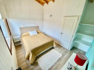 Cette petite chambre comprend un lit et une porte. dans l'établissement Departamentos Tres Maitenes, à Villa La Angostura