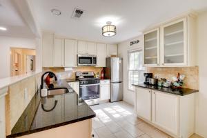 a kitchen with white cabinets and a sink at Charming Home about 4 Mi to Fort Worth Stockyards! in River Oaks