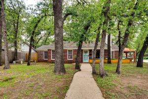 a house with a path in front of a group of trees at Charming Home about 4 Mi to Fort Worth Stockyards! in River Oaks