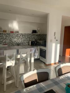 a kitchen with a white table and chairs in a room at Depto Caleta Madryn in Puerto Madryn