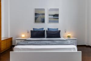 Sinioritsa's House Skopelos في سكوبيلوس تاون: غرفة نوم بسرير ابيض كبير ومصباحين