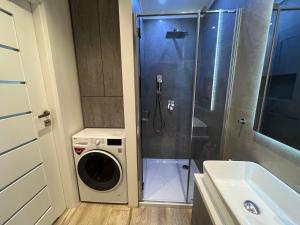 y baño con lavadora y lavadora. en APARTAMENT PAKO z miejscem w garażu podziemnym, en Toruń