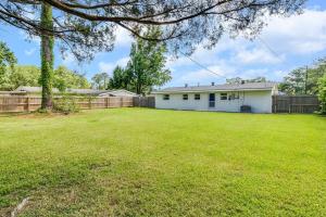 a large yard with a white house and a fence at Central Lafayette location w/King Bed & Coffee Bar in Lafayette