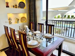 a dining room with a table and chairs and a window at Elegant duplex with pool frontAUC in Cairo