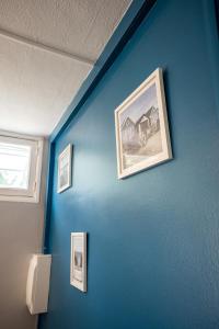 a blue wall with pictures of houses on it at Ti Colibri in Saint-Denis