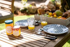a picnic table with plates of food and glasses of orange juice at Ti Colibri in Saint-Denis