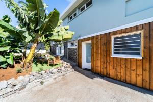 a house with a wooden fence and a tree at Ti Colibri in Saint-Denis