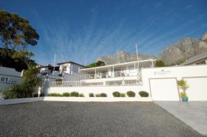a white house with mountains in the background at 61 on Camps Bay in Cape Town