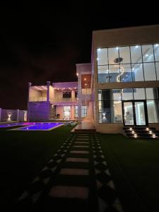 una casa grande por la noche con las luces encendidas en Sky ittin سما إتين, en Salalah