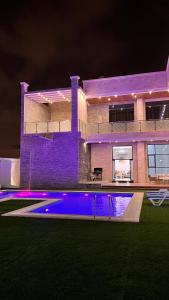 una casa grande con piscina por la noche en Sky ittin سما إتين en Salalah