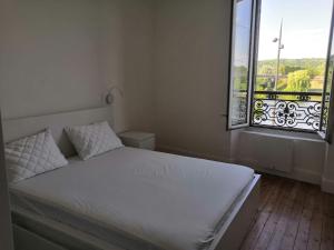 a bedroom with a white bed and a window at Grand 2P Terrasse bord de seine in Mantes-la-Jolie +10 photos
