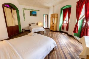 a bedroom with two beds and red and green curtains at Vibes Aurik in Quito