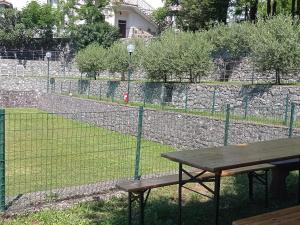 a fence with a picnic table in front of a field at Parco Vacanze Bracchetto Vetta in Carrodano Inferiore