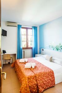 a bedroom with a large bed with two towels on it at Hotel Il Castello in Pozzolengo