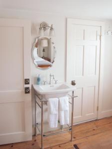 ein Bad mit einem Waschbecken und einem Spiegel in der Unterkunft The General Stanton Inn in Charlestown