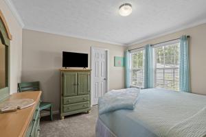 a bedroom with a bed and a tv and a window at Shell Landing Retreat in Beaufort