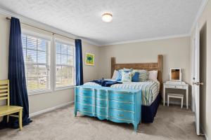 a bedroom with a blue bed with a blue dresser at Shell Landing Retreat in Beaufort