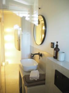 a white bathroom with a sink and a mirror at mi sestre – Studio Apartment Hvar Vrisnik in Jelsa