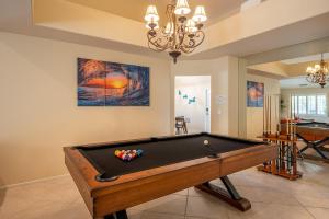 a pool table in a living room with a chandelier at Coachella Chill: Luxury 4BR/4King Paradise Retreat in Indio