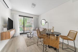 a living room with a couch and a table and chairs at La Vie Suite Cañitas in Buenos Aires