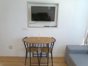 a table and two chairs in a room with a tv at koka vacations 308 Playa del inglés in San Bartolomé de Tirajana